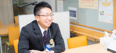 スタッフが施設内で笑顔で対応している様子を撮影した写真。